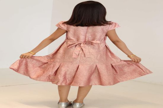 صورة فستان لحمي مع الؤلؤ والريش في نص الفستان